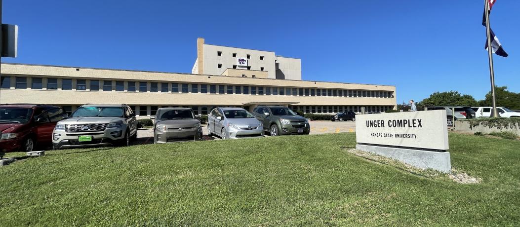 Front of Unger Complex (a tan, multistory brick building) with stone sign in front