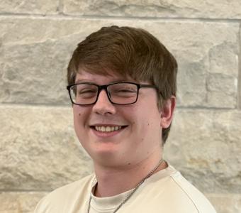 Brendan - headshot in front of limestone wall